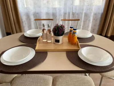 a table with white plates and bottles on a wooden tray at Апартамент Бриз 16 in Sunny Beach
