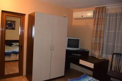 a bedroom with a white cabinet and a desk with a television at Paradise Bay Villas in Sozopol