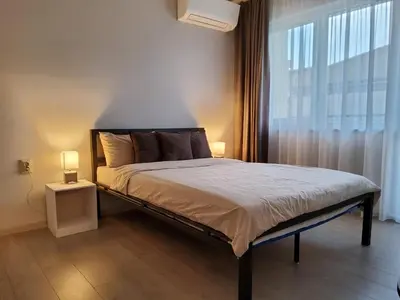 a bed in a room with a large window at апартамент Релакс in Varna City