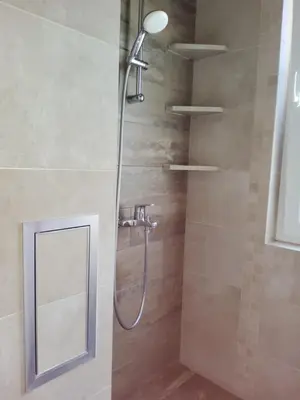 a shower with a shower head and a mirror at апартамент Релакс in Varna City