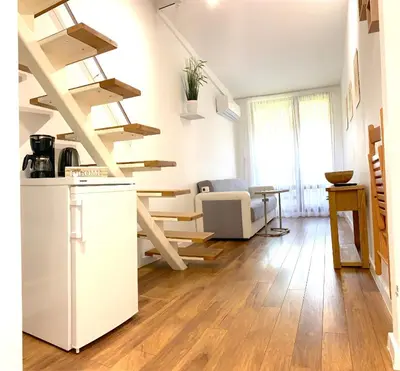 a kitchen and living room with wooden floors and stairs at Апартамент за гости in Varna City