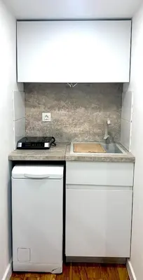 a kitchen with white cabinets and a sink at Апартамент за гости in Varna City
