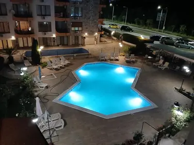 a swimming pool in a courtyard at night at Комплекс Бриз / Breeze Complex Apartments in Sunny Beach