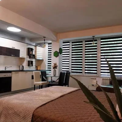 a bedroom with a large bed and a kitchen at Ika studio in Burgas City