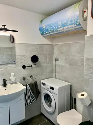 a bathroom with a washing machine and a sink at Seaview Holiday - Черноморска почивка in Aheloy