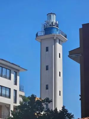 a lighthouse in front of a building with a blue sky at Seaview Holiday - Черноморска почивка in Aheloy