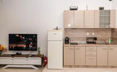 a kitchen with a white refrigerator and a tv at Луксозен апартамент Далия in Varna City