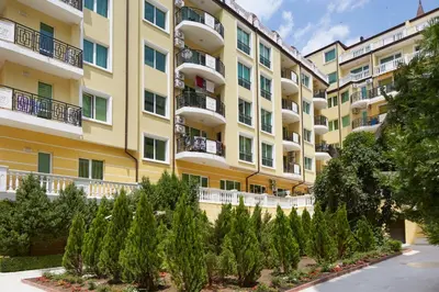 an apartment building with trees in front of it at Hotel Amore Beach - All Inclusive in Elenite