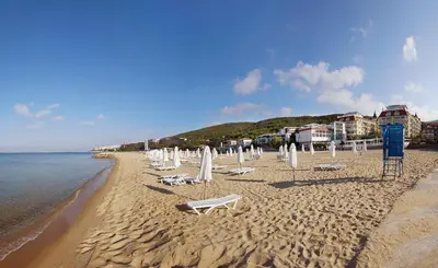 a beach with chairs and umbrellas and the water at Hotel Amore Beach - All Inclusive in Elenite