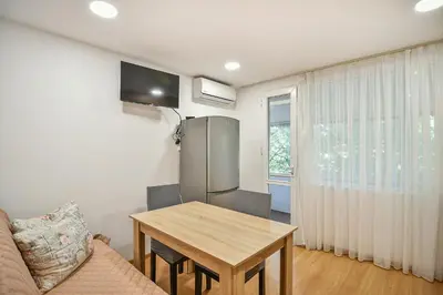 a living room with a table and a refrigerator at Hideout in heart of Varna with WiFi in Varna City