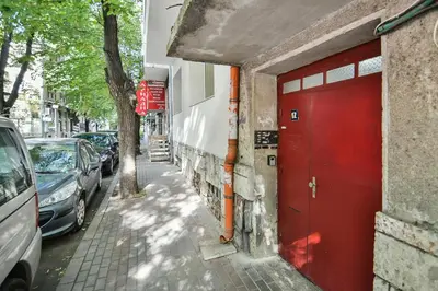 a red door on the side of a building with parked cars at Hideout in heart of Varna with WiFi in Varna City