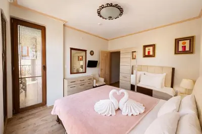 two white swans on a bed in a bedroom at Royal Bay-I Seaview Apartment in Sveti Vlas