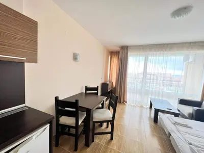 a living room with a table and chairs in a room at Magic Dreams St Vlas in Sunny Beach