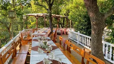 a long table with white tables and a tree at Hotel Gamartata in Duni