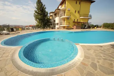 a large swimming pool in front of a building at Menada Green Hills Apartments in Sozopol