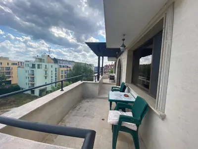 a balcony with two chairs and a table on a building at Apartments Amara Sunny Beach in Sunny Beach