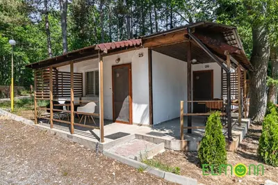 a small cabin with a porch in a forest at Elmona Villas in Kamchia