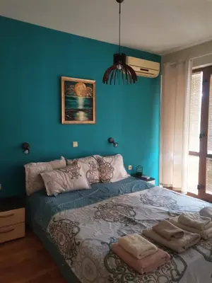 a bedroom with blue walls and a large bed at Апартамент в Oasis beach Kamchia - Лунна пътека in Dolen Bliznak
