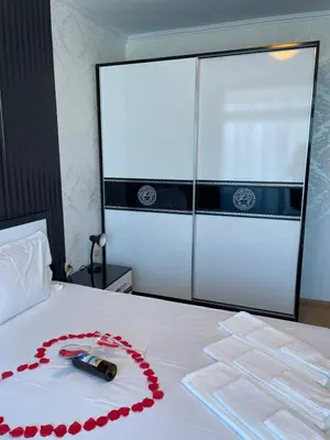 a bed with a remote control and red roses on it at Apart hotel Gallery B in Sunny Beach