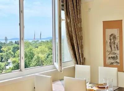 a dining room with a table and chairs and a large window at Alonia - your Burgas shelter by the park and beach in Burgas City