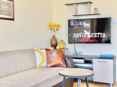 a living room with a couch and a tv at Alonia - your Burgas shelter by the park and beach in Burgas City