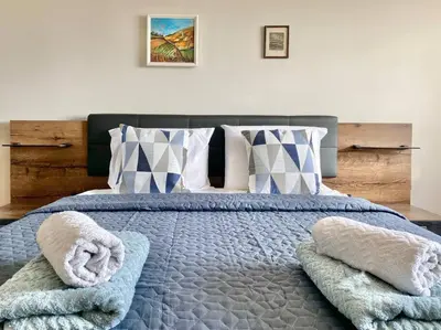 a bedroom with a large bed with towels on it at Alonia - your Burgas shelter by the park and beach in Burgas City