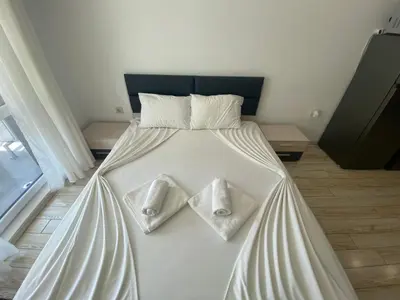 a bed with white sheets and pillows on it at PARADISO 'В' 111 Large Apartment Nessebar in Nesebar