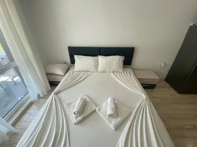a bed with white sheets and white towels on it at PARADISO 'В' 111 Large Apartment Nessebar in Nesebar