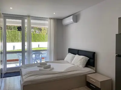 a small bedroom with a bed and a balcony at PARADISO 'В' 111 Large Apartment Nessebar in Nesebar