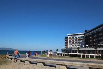 a group of people walking on a beach near a building at PARADISO 'В' 111 Large Apartment Nessebar in Nesebar