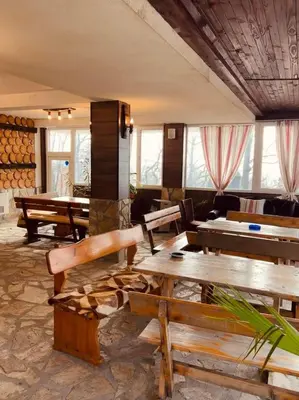 a room with wooden tables and benches and windows at Комплекс Тополица -The beautiful view in Aytos