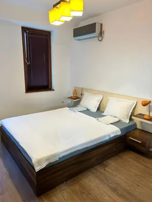 a bedroom with a large bed with white sheets at Голям апартамент с прекрасна гледка кьм морето in Ravda