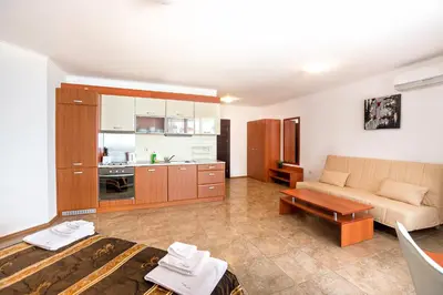a living room with a couch and a kitchen at Apartment complex Mirage of Nessebar in Nesebar