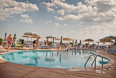 a pool at a resort with people standing around it at Apartment complex Mirage of Nessebar in Nesebar