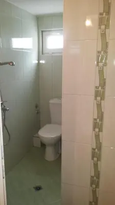 a bathroom with a toilet and a glass shower door at Guest House Margarita in Pomorie