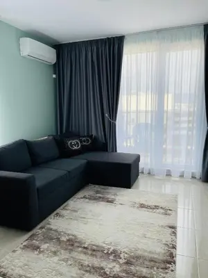 a living room with a couch and a large window at Admiral Plaza in Sunny Beach