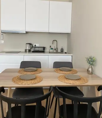 a kitchen with a wooden table with four chairs at Ravda Bliss with a pool in Ravda