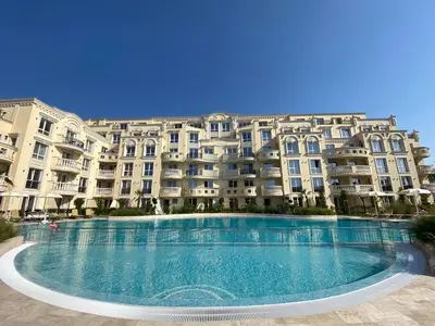 a large swimming pool in front of a large building at Ravda Bliss with a pool in Ravda