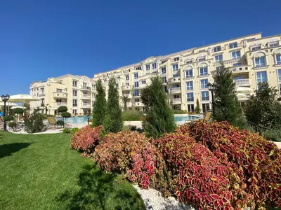 a large apartment building with a garden in front of it at Ravda Bliss with a pool in Ravda