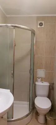a bathroom with a shower and a toilet and a sink at Илеа апартамент in Burgas City