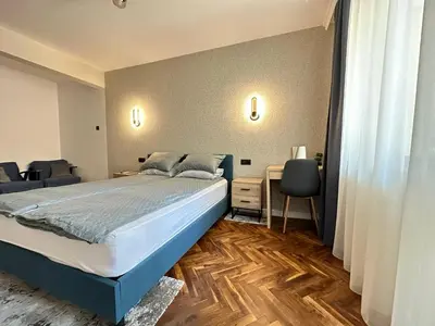 a bedroom with a bed and a desk with chairs at Varna Cathedral Boutique Apartment in Varna City