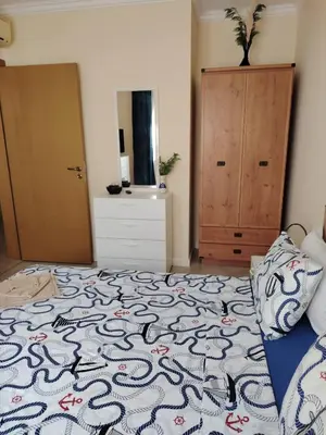 a bedroom with a bed and a dresser at Санта Марина-Сладка къща in Sozopol