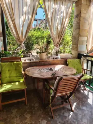 a wooden table and chairs on a patio at Санта Марина-Сладка къща in Sozopol
