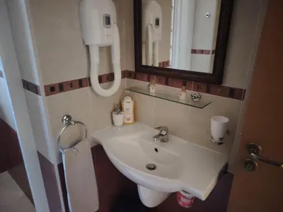 a bathroom with a sink and a mirror at Санта Марина-Сладка къща in Sozopol