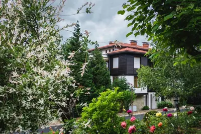a house surrounded by trees and flowers at Санта Марина-Сладка къща in Sozopol