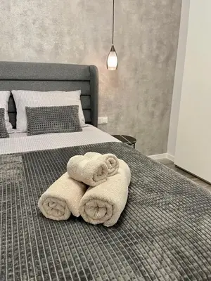 a bedroom with a bed with towels on it at Vanquish Central Apartment in Varna City