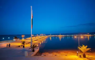 a large body of water at night with people walking around at Family Hotel Electra in Pomorie