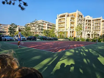 a man playing tennis on a tennis court at Apartament Harmony in Sunny Beach