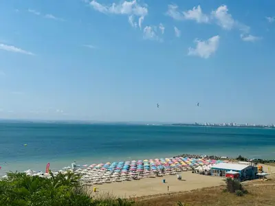a beach with a bunch of umbrellas and the ocean at Coastal Vibes Studio Burgas by Flat Mаnаger in Burgas City
