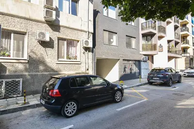 a black car parked in a parking lot next to a building at Central flat Wi-Fi & streaming in Varna City